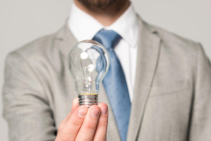 Cropped view of businessman holding light bulb